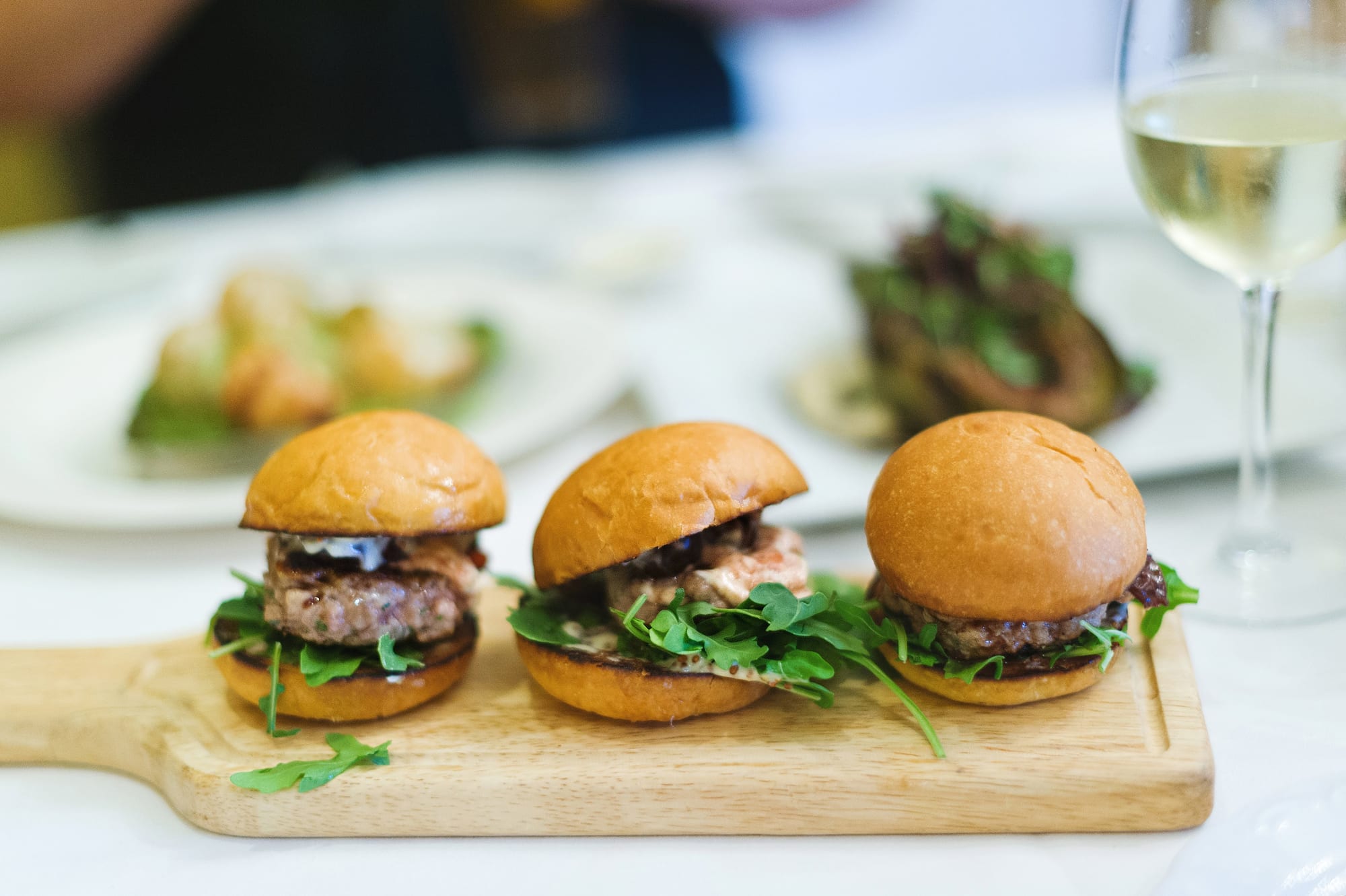 House-made sliders on a wood board at an independent restaurant